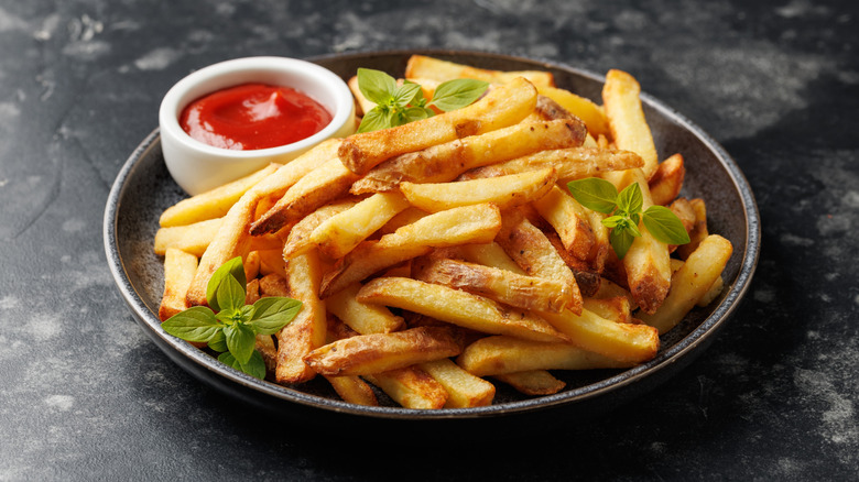 Plate of french fries with ketchup and garnish