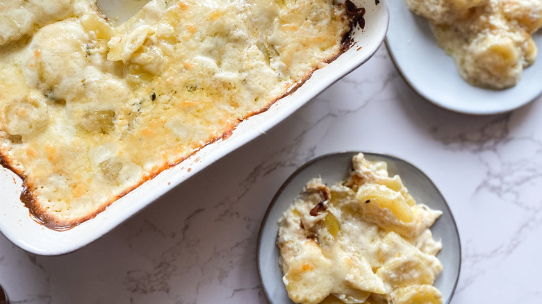 Potatoes au gratin in casserole dish and plate