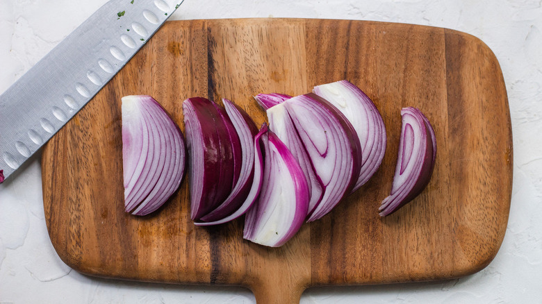 Sliced red onion on board