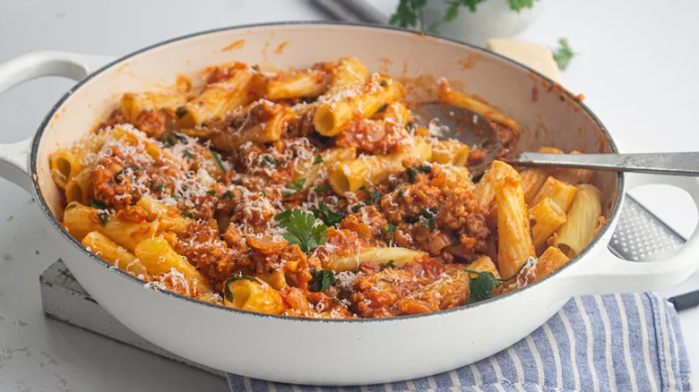 Large shallow skillet with pasta and meat mixture. 