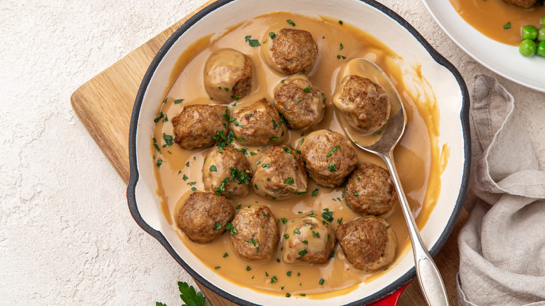 Meatballs in creamy gravy in a white dish.