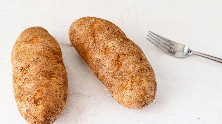 raw russet potatoes and fork