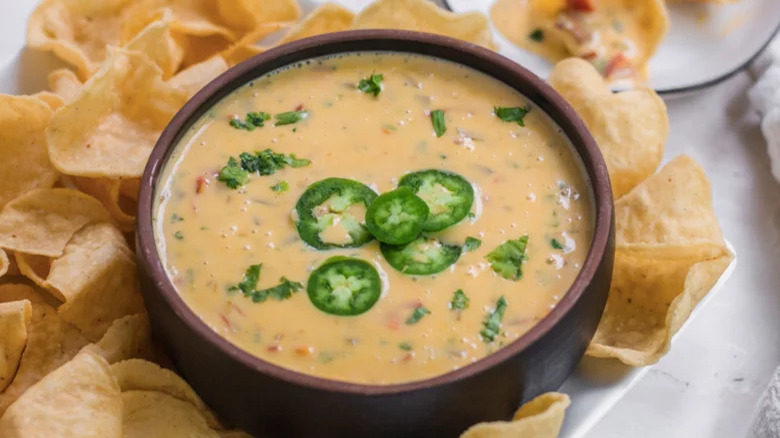 A bowl of queso with chips