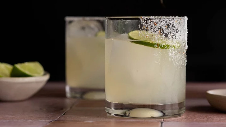 Two short glasses with margarita and salt rims. 