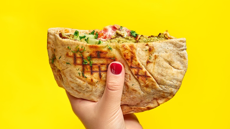 Hand holding up a pita sandwich 