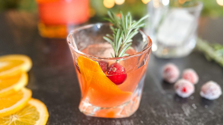 Cocktail with orange peel and cranberries