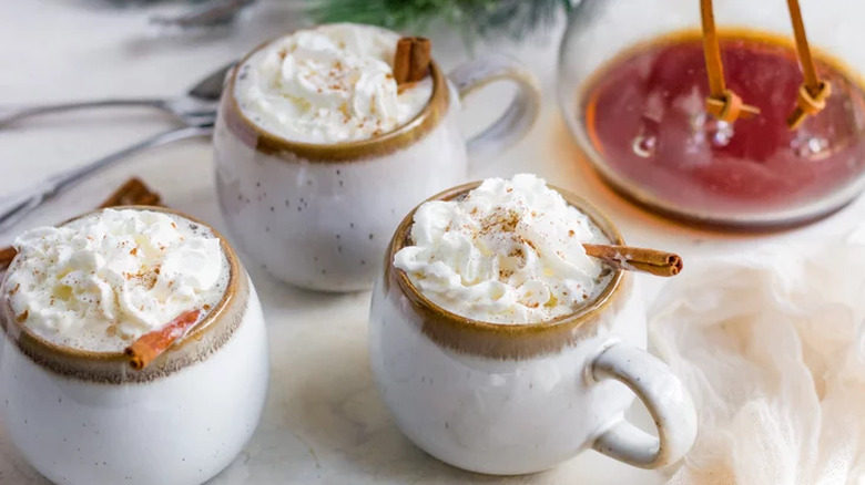 Mugs of whipped cream-topped coffee. 