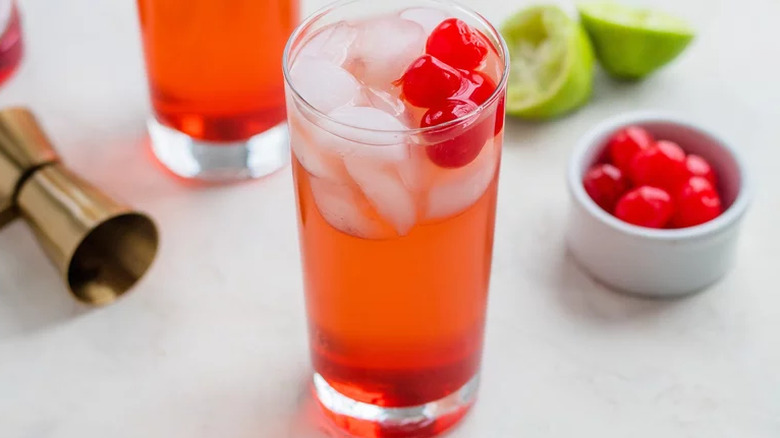 Glass of grenadine, ice, and cherries