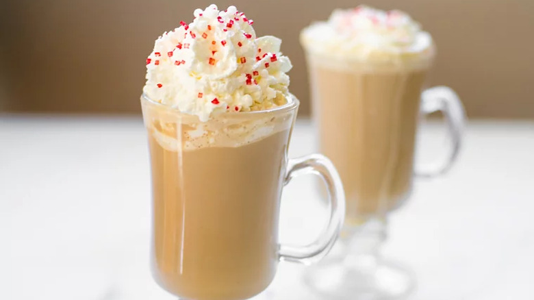 Glass mugs of white chocolate coffee with cream