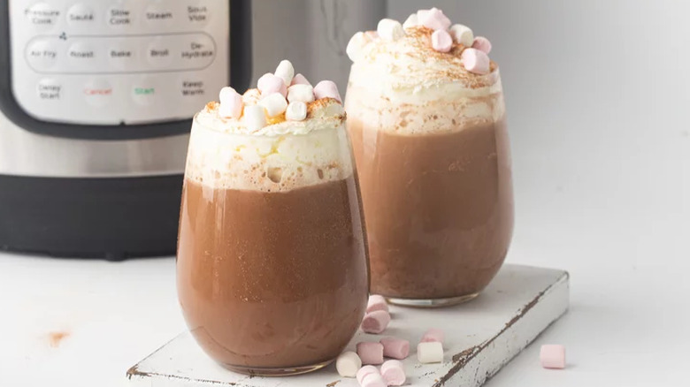 Two glasses of chocolate drink with cream and marshmallows