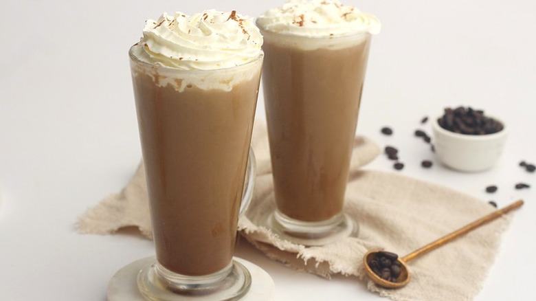 Tall glass mugs of coffee and whipped cream.