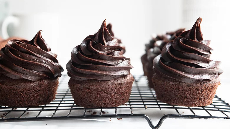 Moist chocolate cupcakes on rack