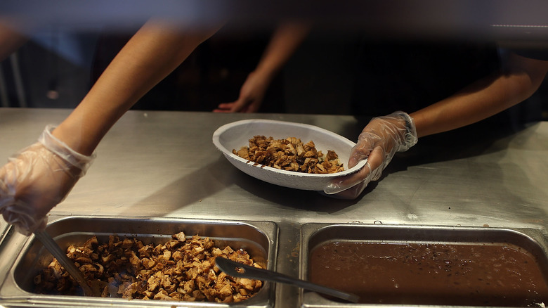 chipotle server making bowl