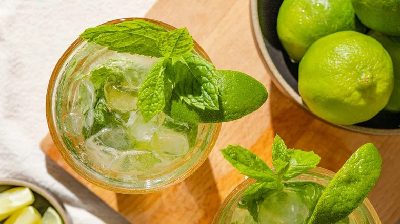 Glasses of ice, mint leaves, seltzer, and lime. 