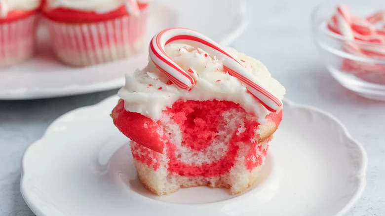 Red and white swirled cupcake topped with candy cane.