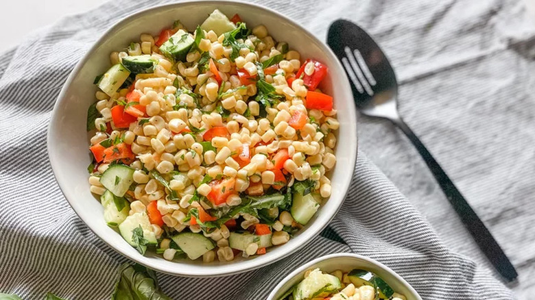 Salad with corn, cucumber, and red pepper in bowl. 