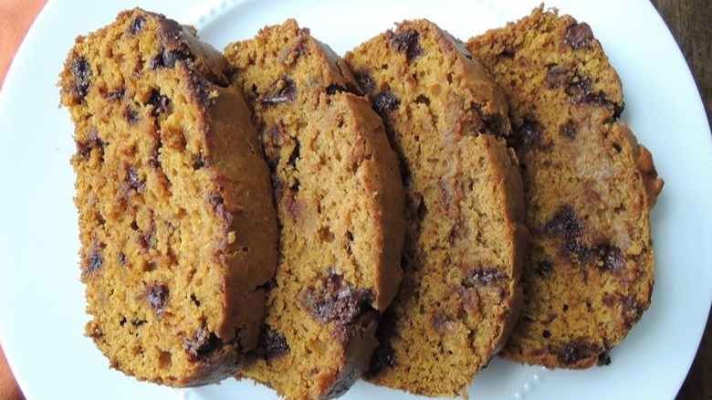 Four slices of pumpkin bread with chocolate chips.