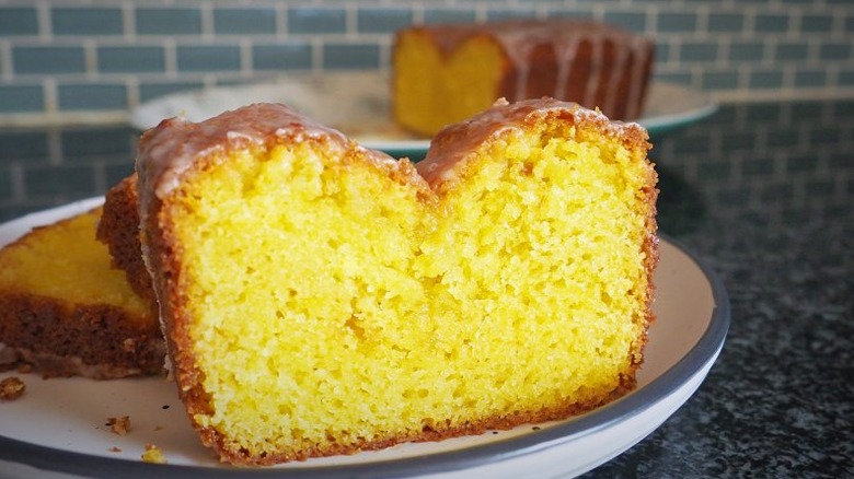 Slice of iced lemon bread on a plate.