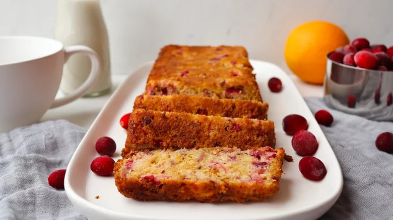 Sliced loaf of cranberry bread with whole cranberries.