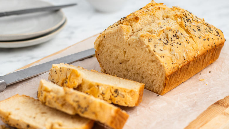 Sliced loaf topped with seeds and oats.