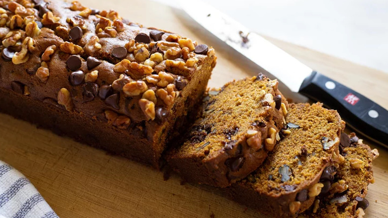 Sliced pumpkin bread topped with chocolate chips and nuts.