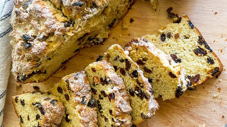 Sliced loaf of Irish soda bread with raisins.