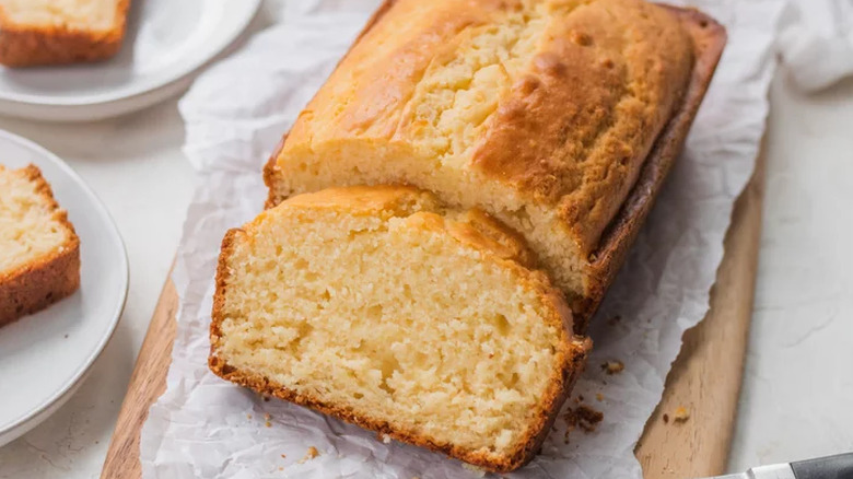 Loaf of plain quick bread on paper-lined board. 