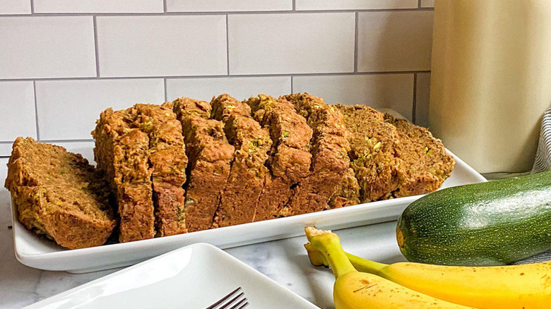 Sliced loaf of quick bread with bananas and zucchini.