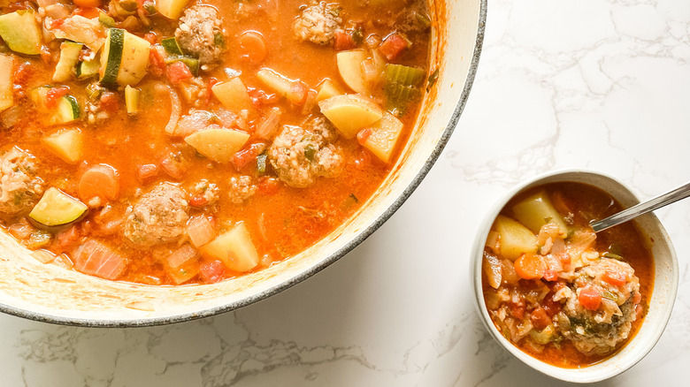 Dutch oven meatball soup with zucchini and potatoes plus serving bowl