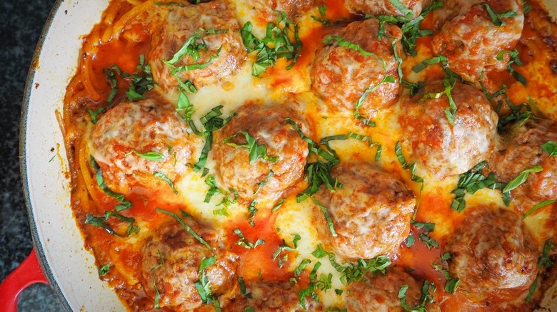 Meatballs and spaghetti with cheese in casserole dish