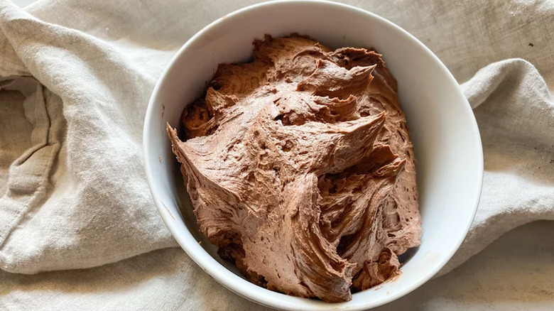 White bowl of chocolate frosting