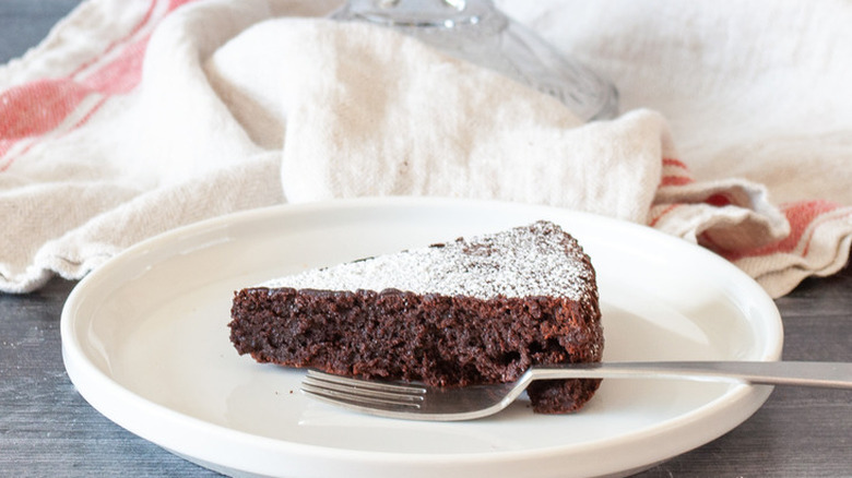 Slice of sugar dusted chocolate cake