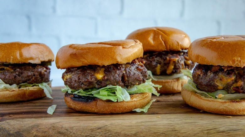 4 hamburgers on wooden table