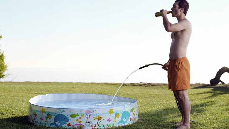 man drinking beer filling pool