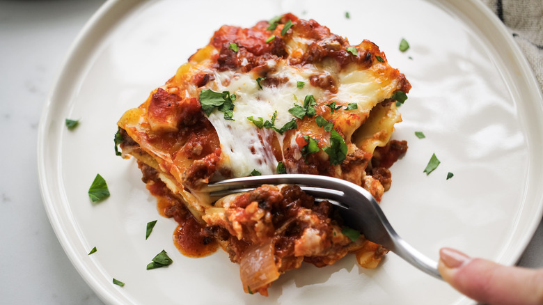 fork digging into lasagna piece