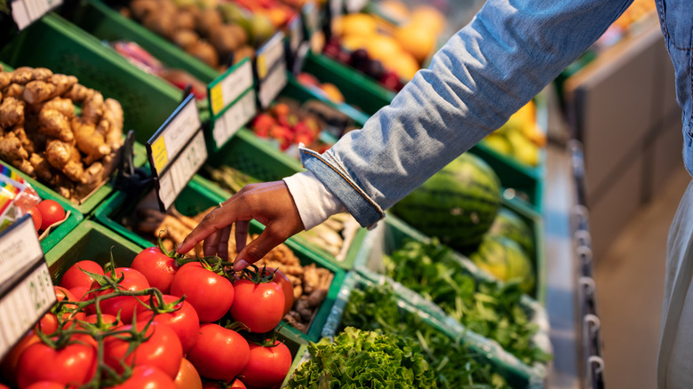 person buying fresh tomatoes