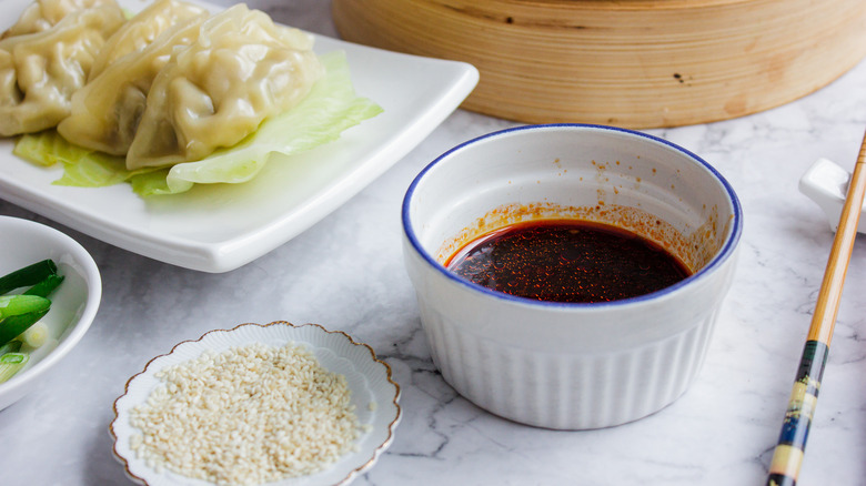 sauce in ramekin with sesame seeds and dumplings