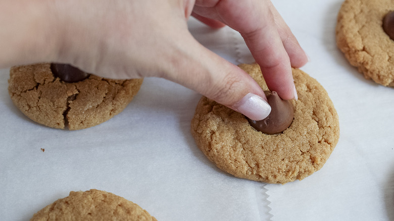 adding chocolate kisses to the cookies