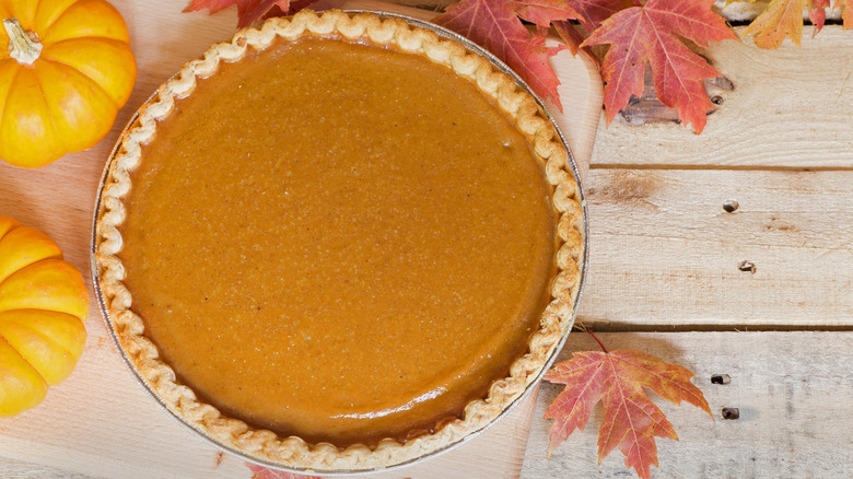 Whole baked pumpkin pie on wood table