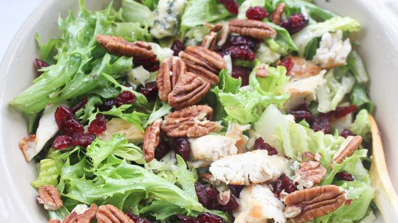 Green salad with dried cranberries and whole pecans.