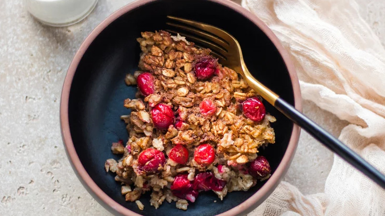 Bowl of cooked oatmeal with whole cranberries. 