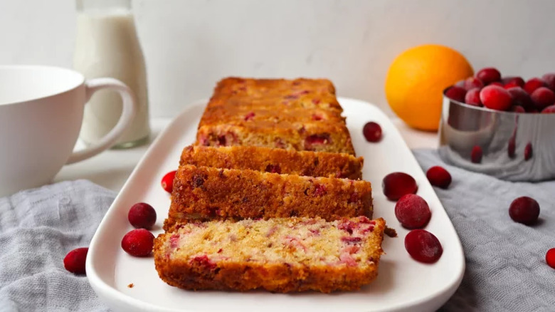 Sliced loaf of cranberry bread with whole cranberries.