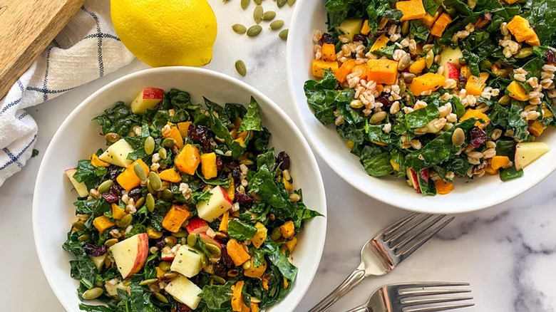 Salads of kale, apple, butternut squash and cranberries.