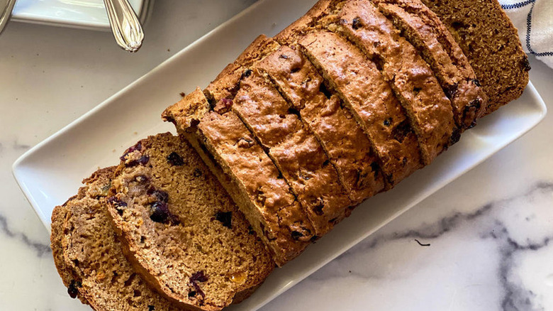 Sliced loaf of bread with dried fruit in the slices.