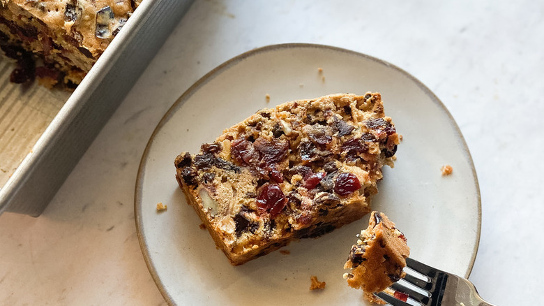 Slice of fruitcake with fork and plate.