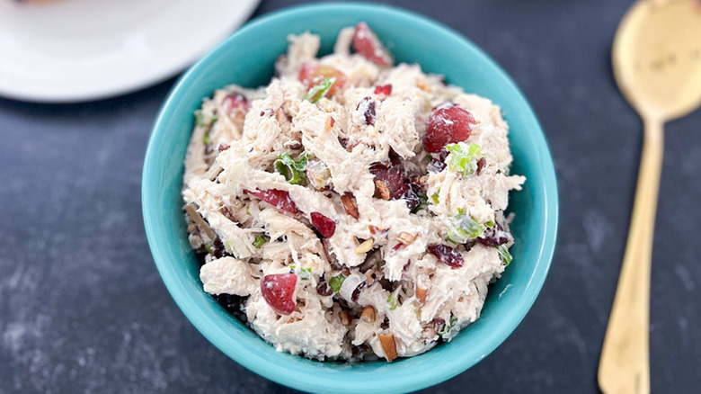 Blue bowl of turkey, grape, and cranberry salad.