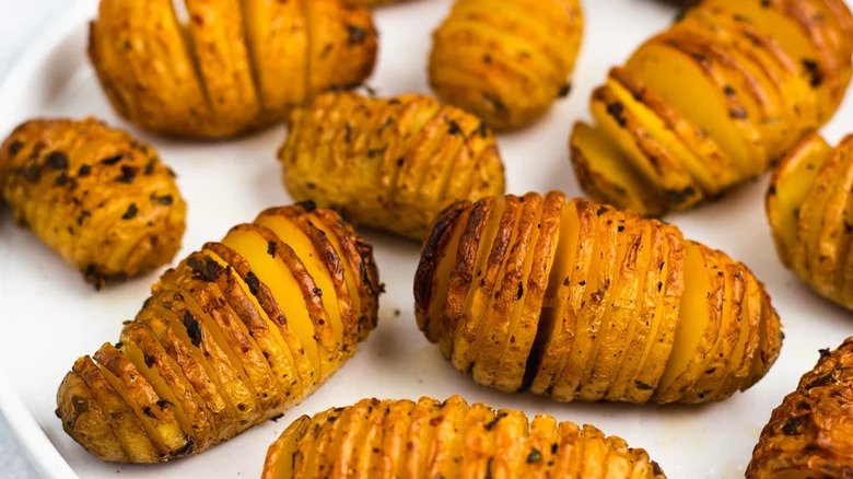 Roast hasselback potatoes on serving plate