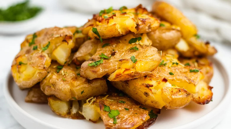 Roasted smashed potatoes piled on plate