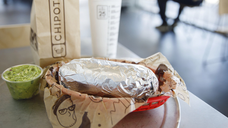 Chipotle burrito, drink and chips on a table