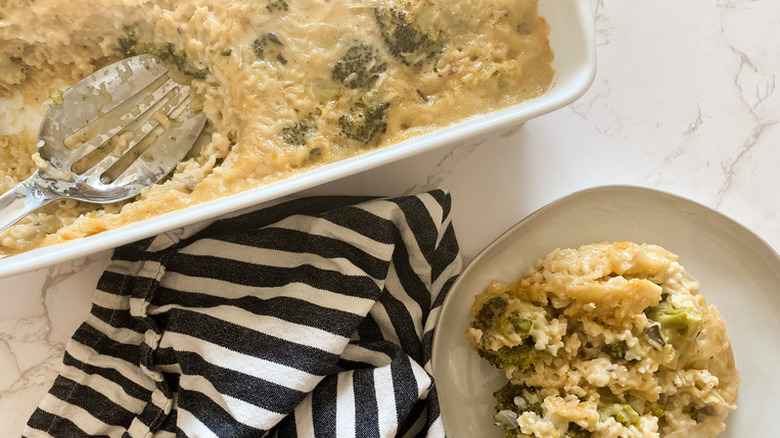 Casserole dish and plate with cheese-rice-broccoli mixture.